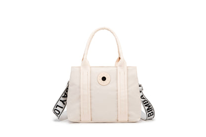 A stylish and structured mini tote designed for everyday elegance. Crafted from durable lightweight nylon in a soft lavender tone, it features dual top handles and a bold adjustable logo strap for versatile carry options