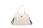 A stylish and structured mini tote designed for everyday elegance. Crafted from durable lightweight nylon in a soft lavender tone, it features dual top handles and a bold adjustable logo strap for versatile carry options